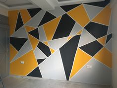 a room that has been painted with yellow and black triangles on it, while the walls are white