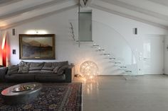 a living room filled with furniture and a spiral staircase leading up to the second floor