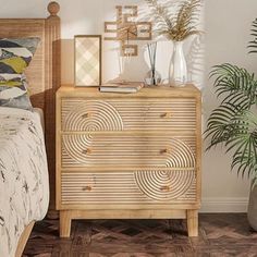 a bedroom scene with focus on the dresser and bed in the foreground, there is a potted plant next to it