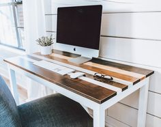 an apple computer sitting on top of a wooden desk