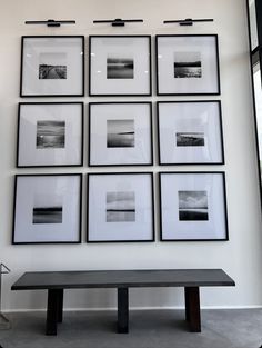 a black and white photo hanging on the wall next to a table with a bench underneath it