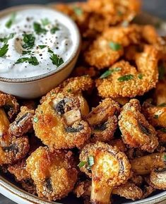 a plate full of fried food with dip in the middle and garnished with parsley