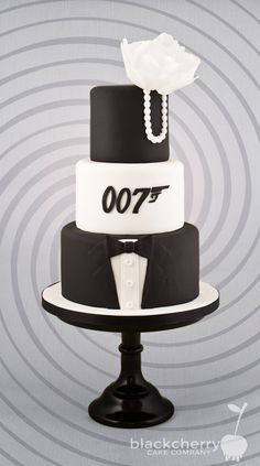 a black and white wedding cake with the james bond symbol on it's side