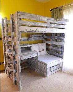 a bunk bed made out of wooden pallets with white mattresses and pillows on top