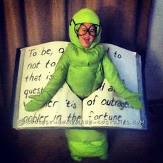 a person in a green frog costume holding a book