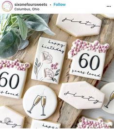 decorated cookies with the number 60 and champagne glasses on them are sitting next to each other