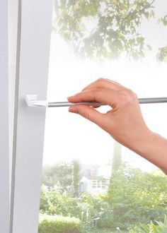 a hand is holding onto the handle of a sliding glass door