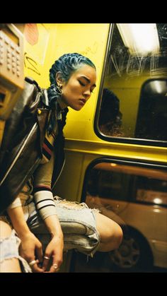 a woman with blue hair sitting on a bus