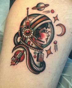 a tattoo on the leg of a person with an astronaut helmet and planets around it