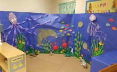 an ocean themed classroom setting with paper cutouts on the wall and sea animals in the background