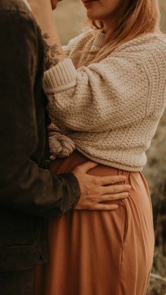 a man and woman standing next to each other with their hands on their hipss