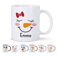 a white mug with an emma face on it and six different colored coffee mugs