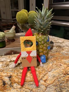 an elf is standing next to a pineapple on a counter top in front of a potted plant