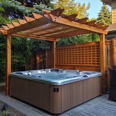 a hot tub sitting under a wooden pergol