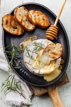 a plate with bread, butter and honey on it