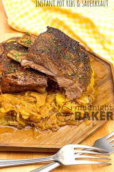 a wooden cutting board topped with meat and potatoes on top of a table next to a fork