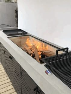 an outdoor fire pit is shown with flames coming out of the top and side panels