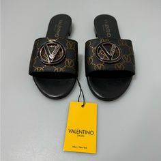 Valentino Carrie Logo Open Toe Sandals Black Women’s 6. New Without Box. Crafted From Superior Leather, These Easy, Breezy Sandals Are Designed With An Open Toe And An Appealing Goldtone Logo Accent. Leather Upper Open Toe Slip-On Style Lining: Leather Padded Insole Synthetic Sole Made In Italy Designer Black Closed Toe Sandals, Designer Black Slip-on Sandals, Black Designer Slip-on Sandals, Designer Black Sandals With Open Heel, Designer Black Slip-on Heels, Sandals Black Women, Valentino Rockstud Sandals, Valentino Sandals, Ankle Strap Sandals Heels