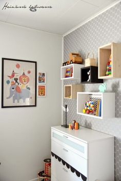 a child's playroom with toys and bookshelves on the wall next to it