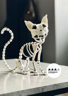 a skeleton cat figurine sitting on top of a table