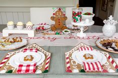 a table set for christmas with gingerbread cookies and desserts