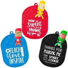 three oven mitts with sayings on them, one has an apple and the other has