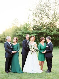 a group of people standing next to each other on top of a lush green field