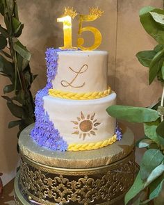 a three tiered cake with purple and yellow decorations