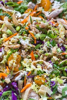 a salad with chicken, lettuce, carrots and other veggies