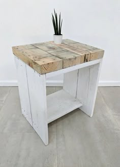 a white wooden table with a potted plant on it's top and bottom