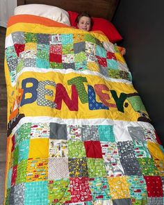 a young boy laying in bed under a blanket with the word benev written on it