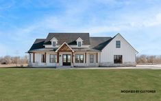 a large white house sitting on top of a lush green field