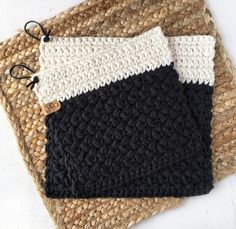 two black and white crocheted placemats sitting on top of each other