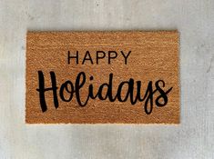 a happy holidays door mat with the words happy holidays written on it in black ink