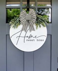 a sign that says fame sweet home hanging on a door with a bow and greenery