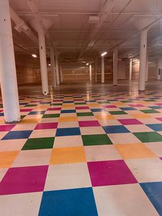 an empty parking garage with multicolored tiles on the floor