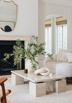 a living room with white furniture and a fireplace