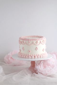 a white cake with pink frosting and flowers