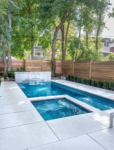 an outdoor swimming pool in the middle of a yard with trees and bushes around it