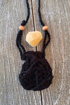 a crocheted bag with a wooden bead hanging from it's side