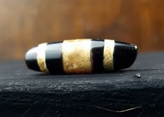 a black and white striped ring sitting on top of a piece of wood