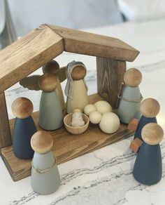 a wooden nativity scene with figurines and eggs