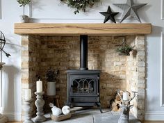 a wood burning stove sitting in a living room next to a fire place and christmas decorations