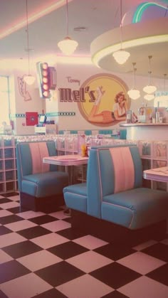 the interior of a diner with checkered flooring and blue booth booths, tables and chairs