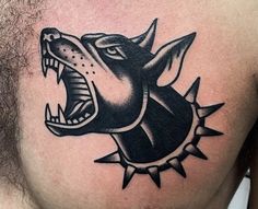 a man's chest with a black and white tattoo of a growling dog on it