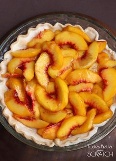 a pie with sliced peaches in it on a table