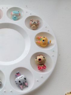 a white tray with twelve different animal figurines arranged in the shape of a circle