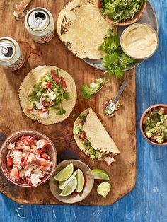 mexican food on a wooden cutting board with salsa and guacamole next to it