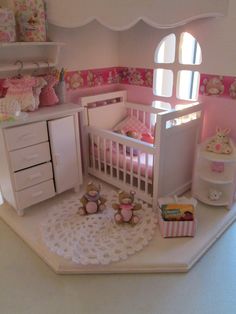 a doll house with a crib, dresser and bed in the corner next to two teddy bears