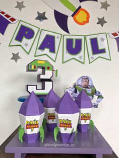 an image of a party decoration with purple and green decorations on the table for paul's 5th birthday